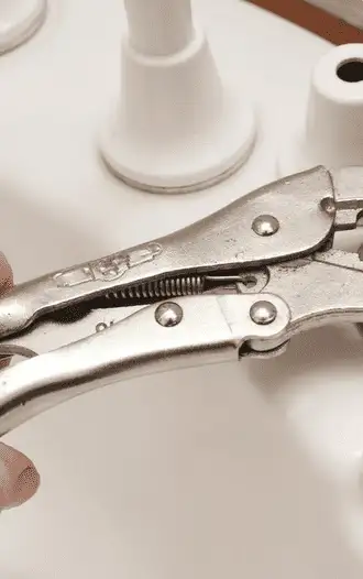 un plombier resserre un tuyau à l'aide d'une clé à molette